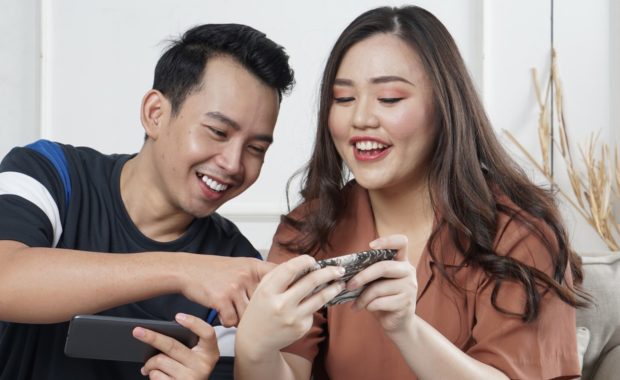 man and woman looking at phone screen
